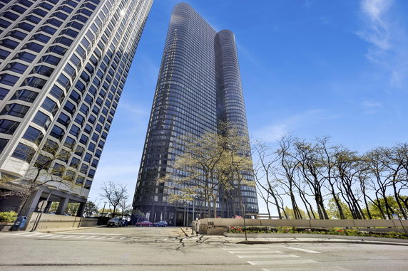 Front view of a modern high-rise building with a curved glass facade.