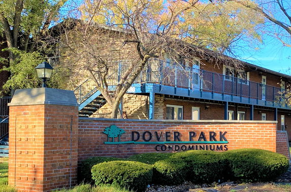 Front view of a condominium building with a brick and metal railing structure.
