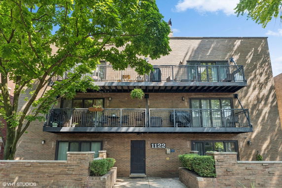 Front view of a multi-story brick building with balconies.