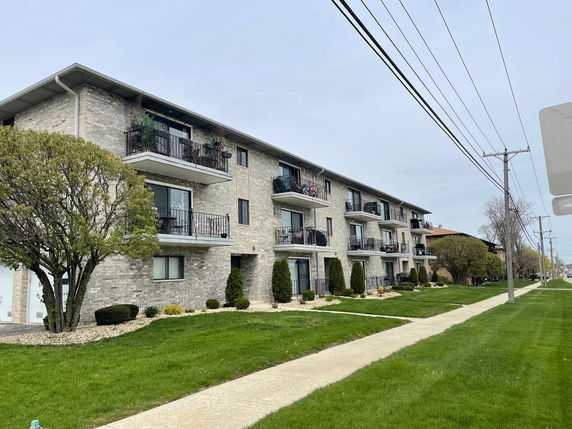Front view of a three-story apartment building with balconies.