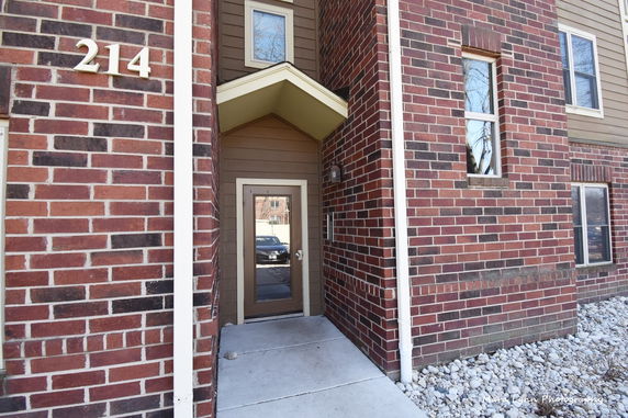 Front view of a building entrance with brick exterior and house number 214.