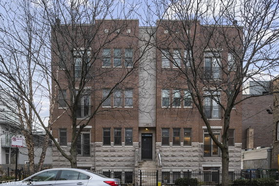 Front view of a multi-story brick building with multiple windows and a central entrance.