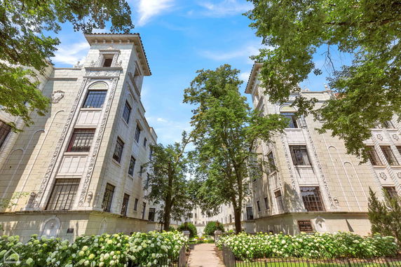 Front view of a historic multi-story building with decorative facade and tall windows.