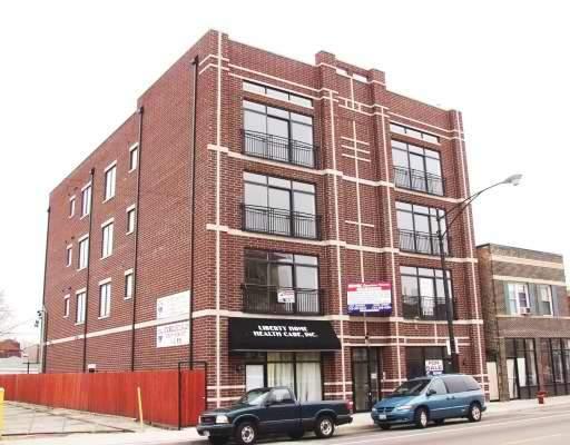 Front view of a four-story brick building with large windows.