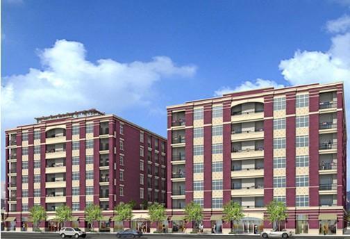 Front view of two multi-story apartment buildings with a red and beige exterior.