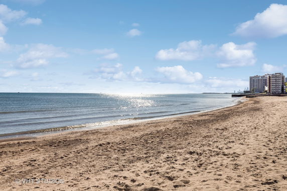 Panoramic view of a beachfront with buildings in the distance.