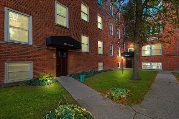 Front view of a brick apartment building with multiple windows and entrance doors.
