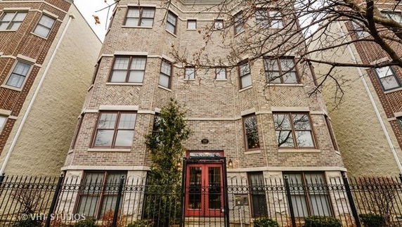 Front view of a multi-story brick building with multiple windows.