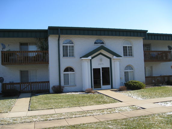 Front view of a two-story building with a central entrance and balconies on either side.