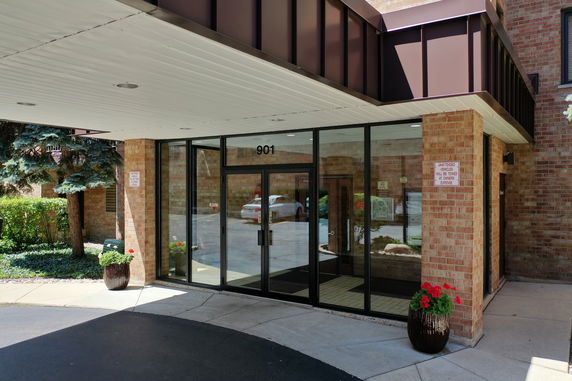 Front view of a building entrance with glass doors and brick facade.