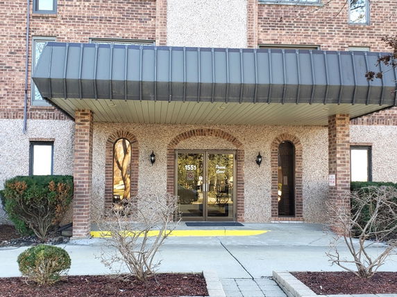 Front view of a building with brick and concrete facade and entrance canopy.