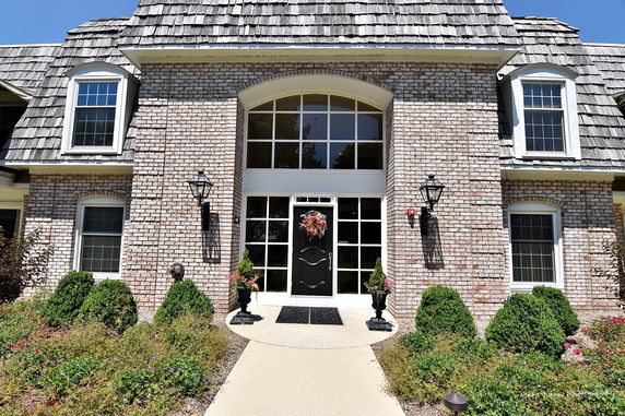 Front view of a house with brick exterior and multiple windows.