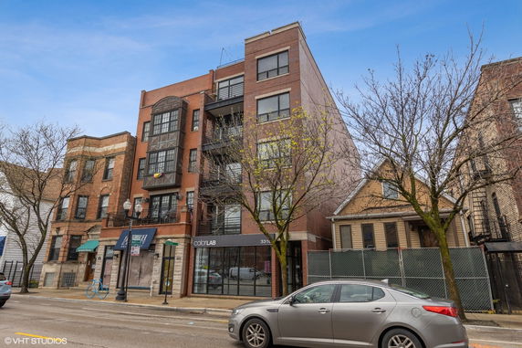 Front view of a multi-story commercial building with brick facade and large glass windows on the ground floor.