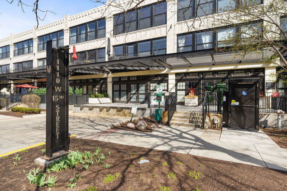Front view of a multi-story building with large windows and metal awnings.