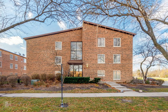 Front view of a multi-story brick building with multiple windows and a central entrance.