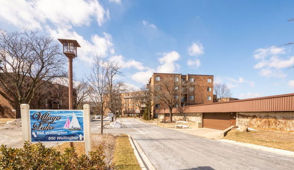 Front view of a multi-story brick building with adjacent parking area.