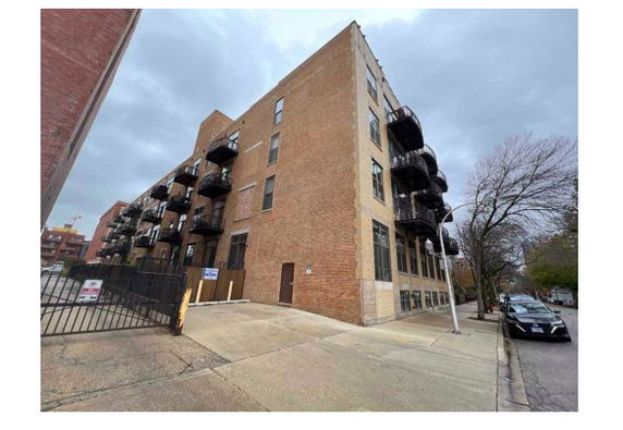 Front view of a multi-story brick apartment building with balconies.
