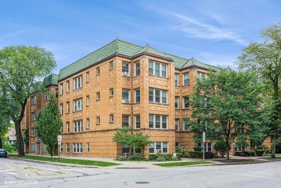 Front view of a multi-story brick building with a green roof.