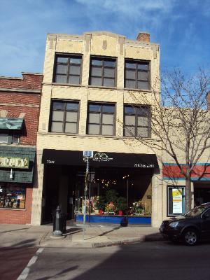Front view of a three-story commercial building with a storefront at street level.