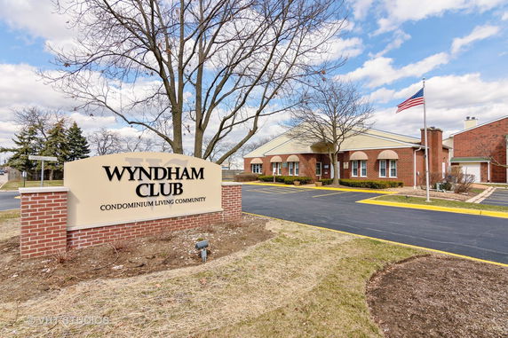 Front view of a brick community building with a sign reading Wyndham Club.