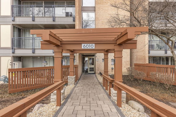 Front view of a building with a wooden pergola entrance.