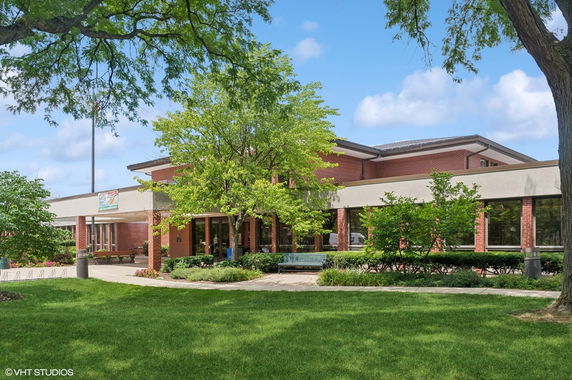 Front view of a two-story brick building with large windows.