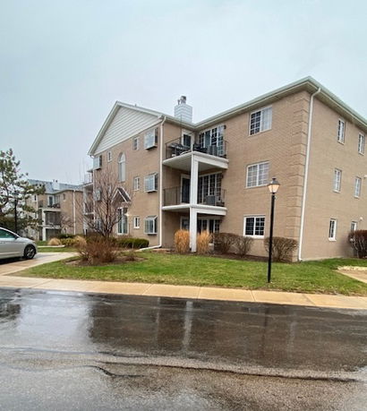 Front view of a multi-story apartment building with balconies.