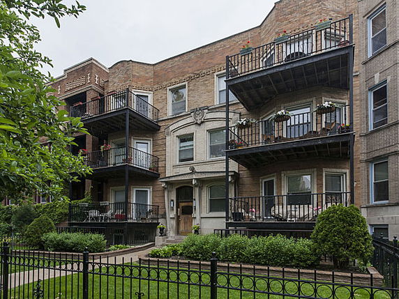Front view of a multi-story apartment building with balconies.