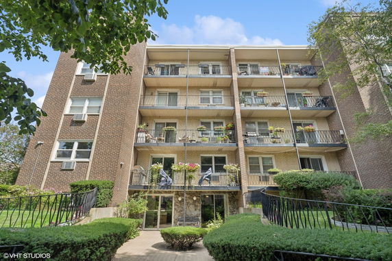 Front view of a multi-story apartment building with balconies.