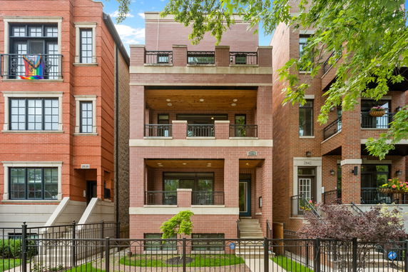 Front view of a multi-story brick building with balconies.