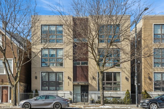 Front view of a modern three-story building with large windows.