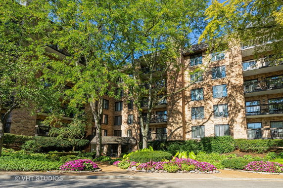 Front view of a multi-story residential building with brick exterior and balconies.