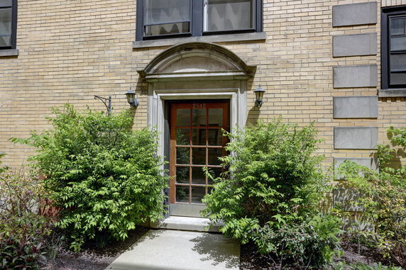 Front view of a building entrance with a brick exterior and decorative arch.