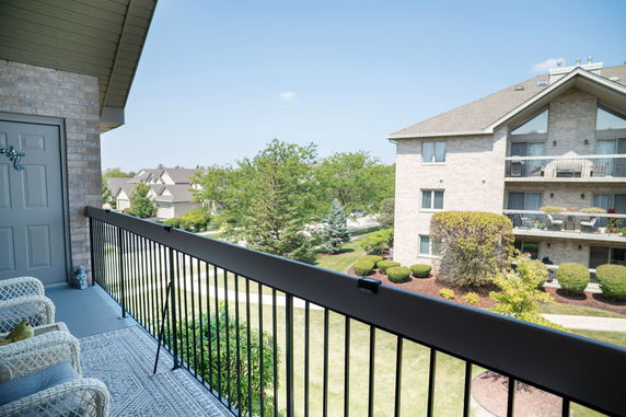Panoramic view of surrounding buildings and greenery from a balcony.