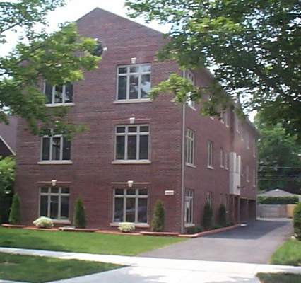 Front view of a multi-story brick building with multiple windows.