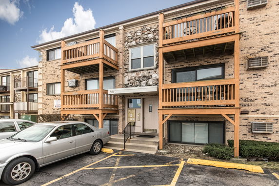 Front view of a multi-story apartment building with balconies.