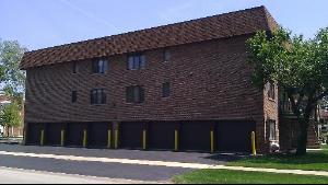 Front view of a multi-story building with multiple garage doors on the ground level.