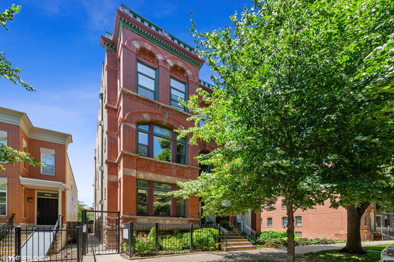 Front view of a multi-story brick building with decorative arches.