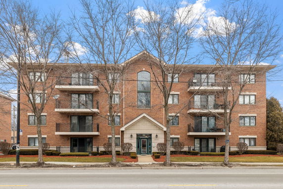 Front view of a multi-story brick building with balconies.