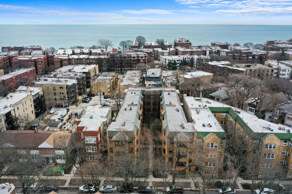 Aerial view of apartment buildings with a body of water in the background.