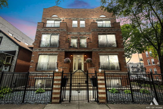 Front view of a three-story brick building with a central entrance and multiple windows.