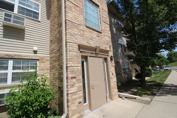 Front view of a multi-story building with brick and siding exterior.
