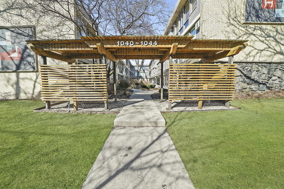 Front view of a building entrance with a wooden pergola.