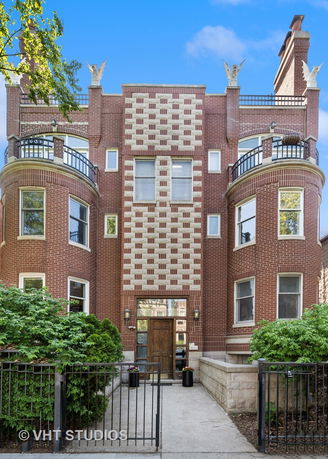Front view of a multi-story brick building with decorative architectural details.
