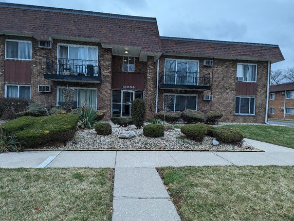 Front view of a two-story apartment building with balconies.