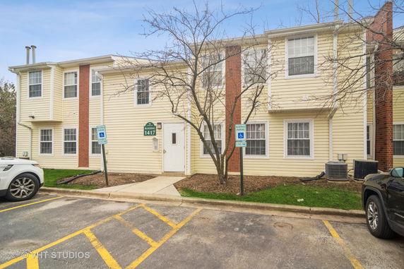 Front view of a two-story building with parking spaces in front.
