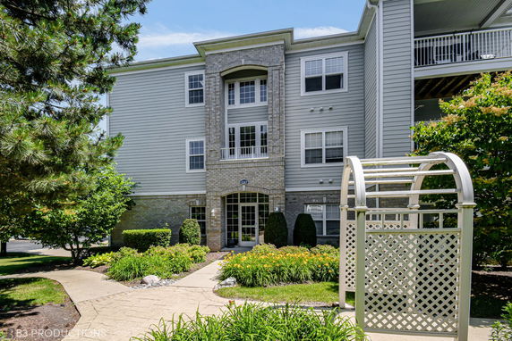 Front view of a multi-story residential building with brick and siding exterior.