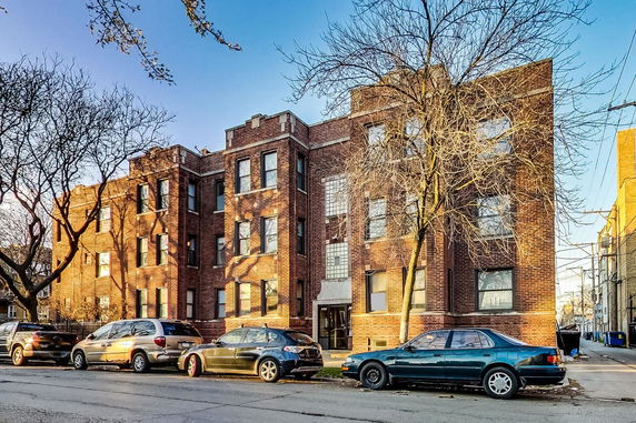 Front view of a multi-story brick apartment building.