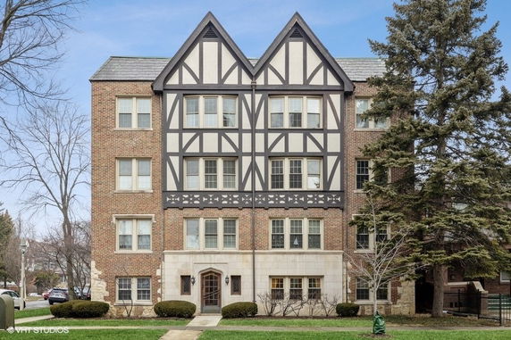 Front view of a multi-story Tudor-style brick building.