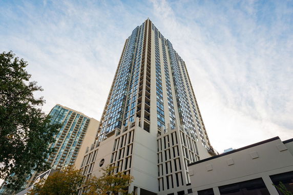 View of a tall high-rise building from the ground, with a modern exterior and numerous windows.